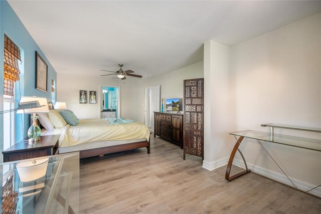 Bedroom featuring light wood-style flooring, ceiling fan, and ensuite bathroom