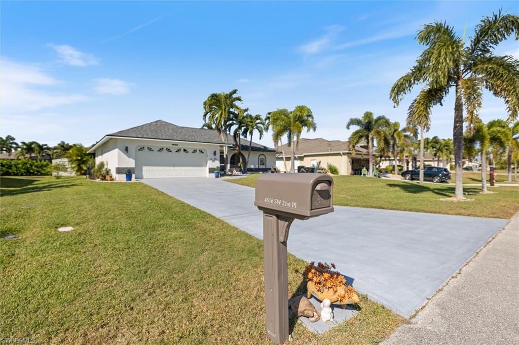 Single story home with driveway, a front yard, and an attached garage