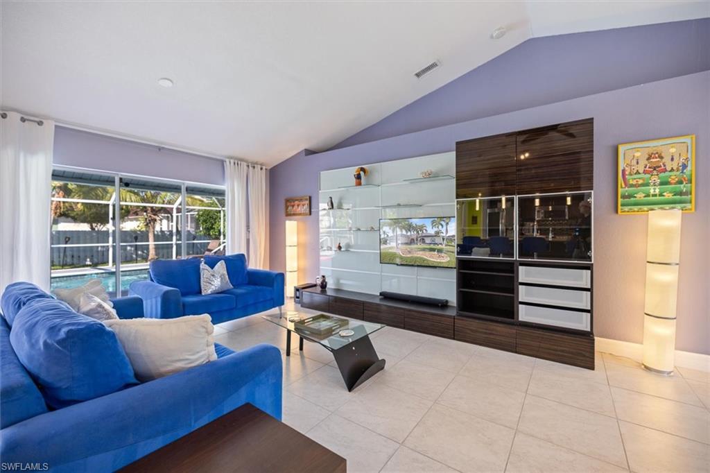 Tiled living area featuring vaulted ceiling