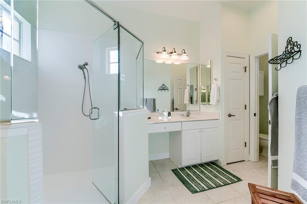 Primary bath has sinks separated by shower