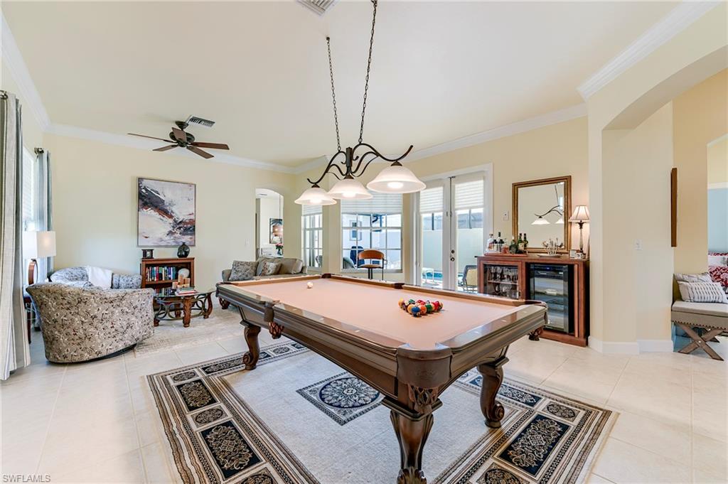 French doors to the pool are visible at the center rear and a conversation seating area to the left rear