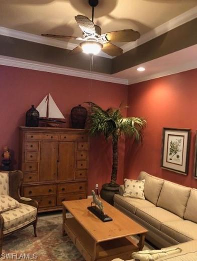 Living room with ceiling fan and crown molding