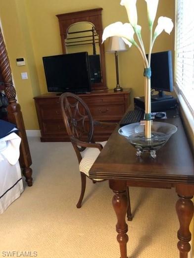 Carpeted office featuring a notable chandelier