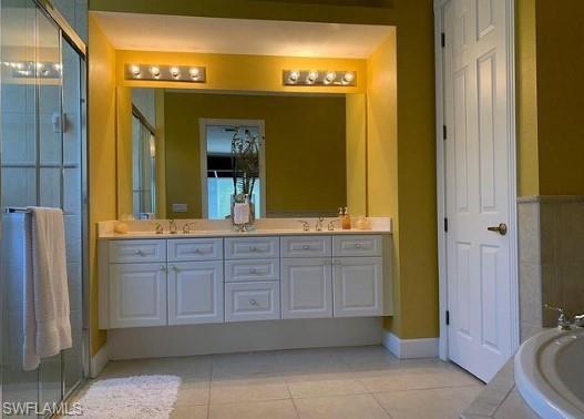 Bathroom with plus walk in shower, vanity, and tile patterned floors