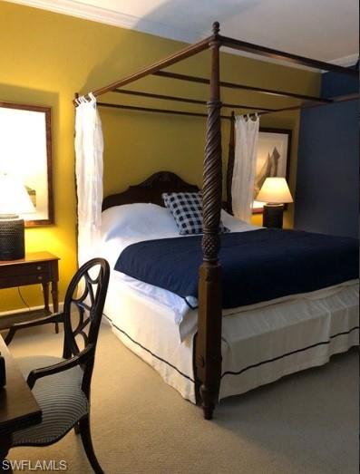Carpeted bedroom featuring crown molding