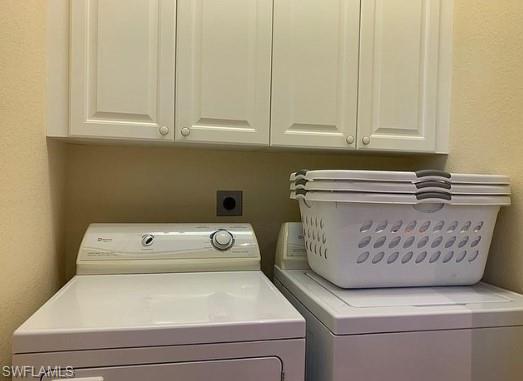 Clothes washing area featuring cabinets and washing machine and clothes dryer
