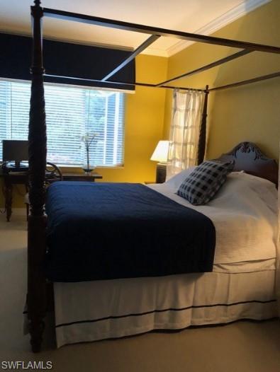 Bedroom featuring ornamental molding and carpet floors