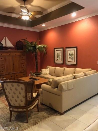 Tiled living room featuring crown molding and ceiling fan