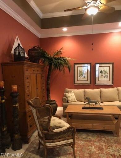 Living area with crown molding and ceiling fan
