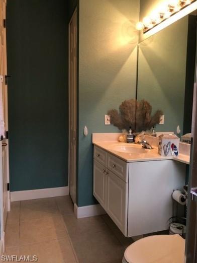 Bathroom featuring toilet, vanity, and tile patterned floors
