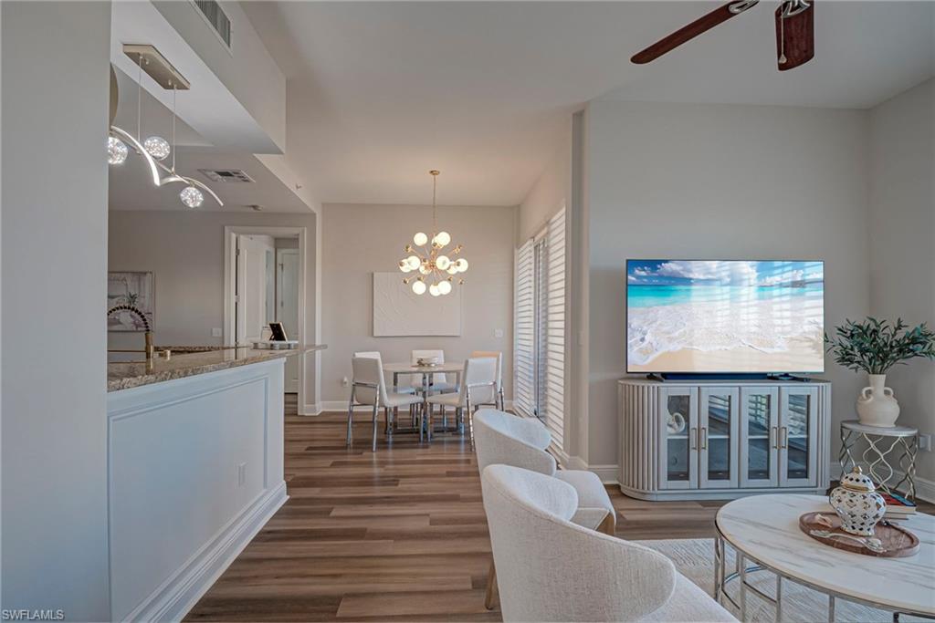 Living area featuring new floors, a chandelier, and ceiling fan