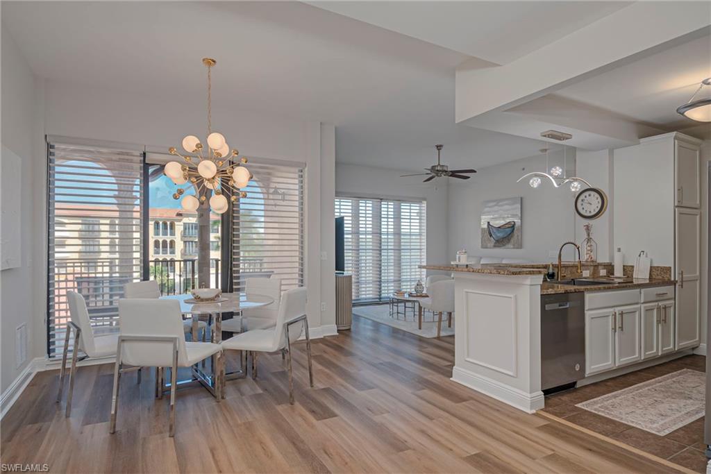 Dining room with ceiling fan, light wood-style floors, and a chandelier