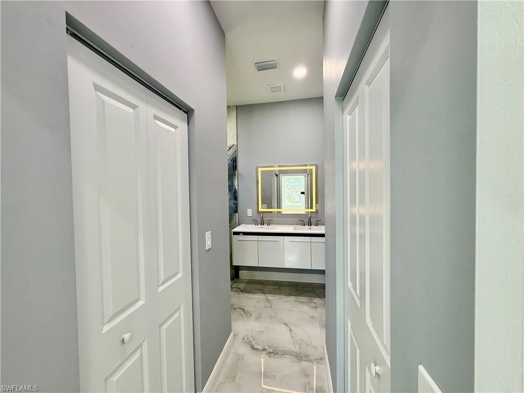 Spare room featuring a tray ceiling, light marble finish floors, recessed lighting, and a ceiling fan