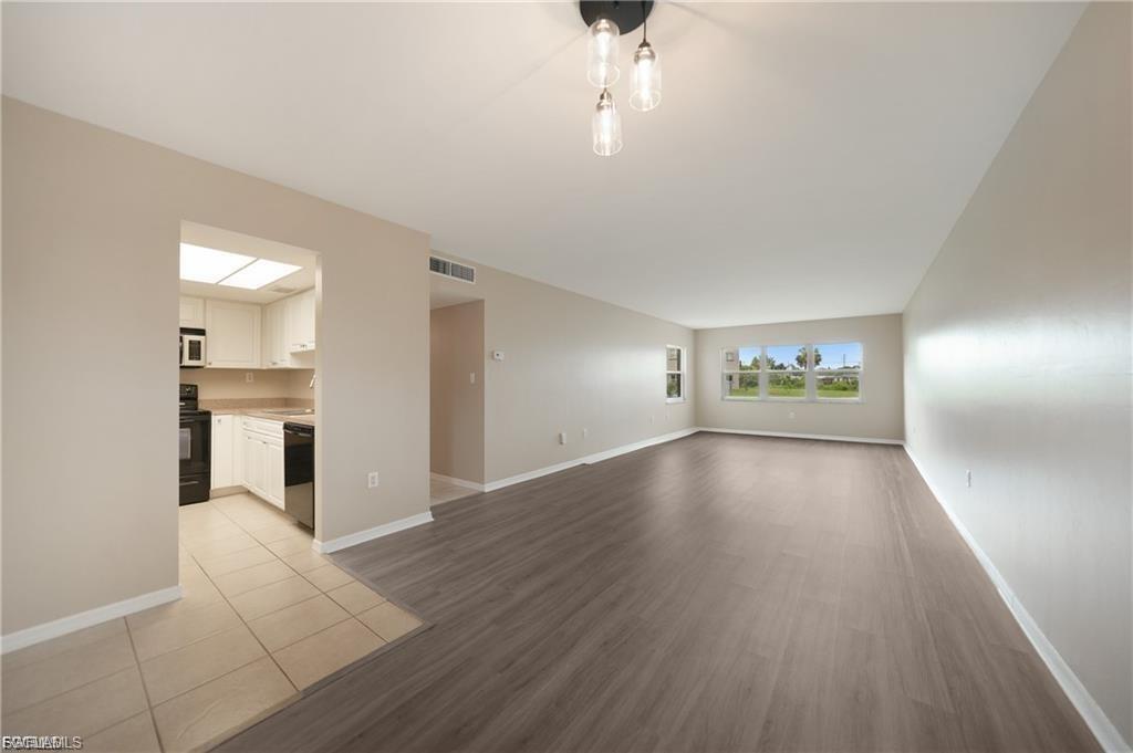 Unfurnished living room with light wood-style floors and baseboards