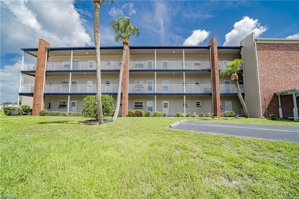 View of apartment building / complex featuring uncovered parking