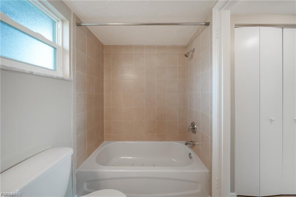 Bathroom with washtub / shower combination and a closet