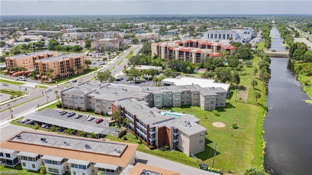 Drone / aerial view of a nearby body of water and apartment complex / building