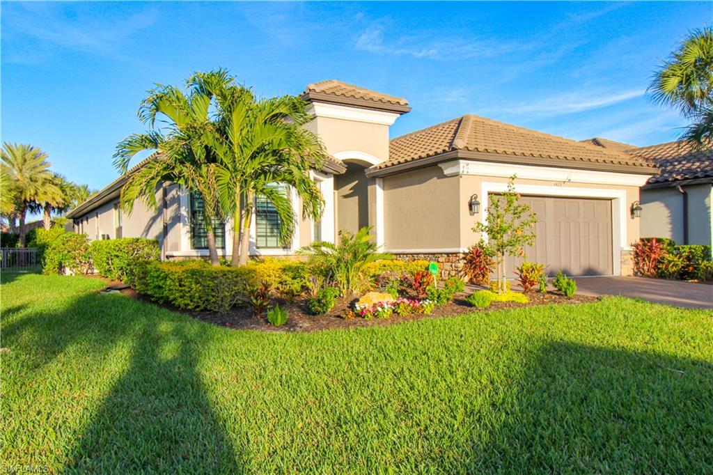 Mediterranean / spanish-style house with a garage and a front lawn