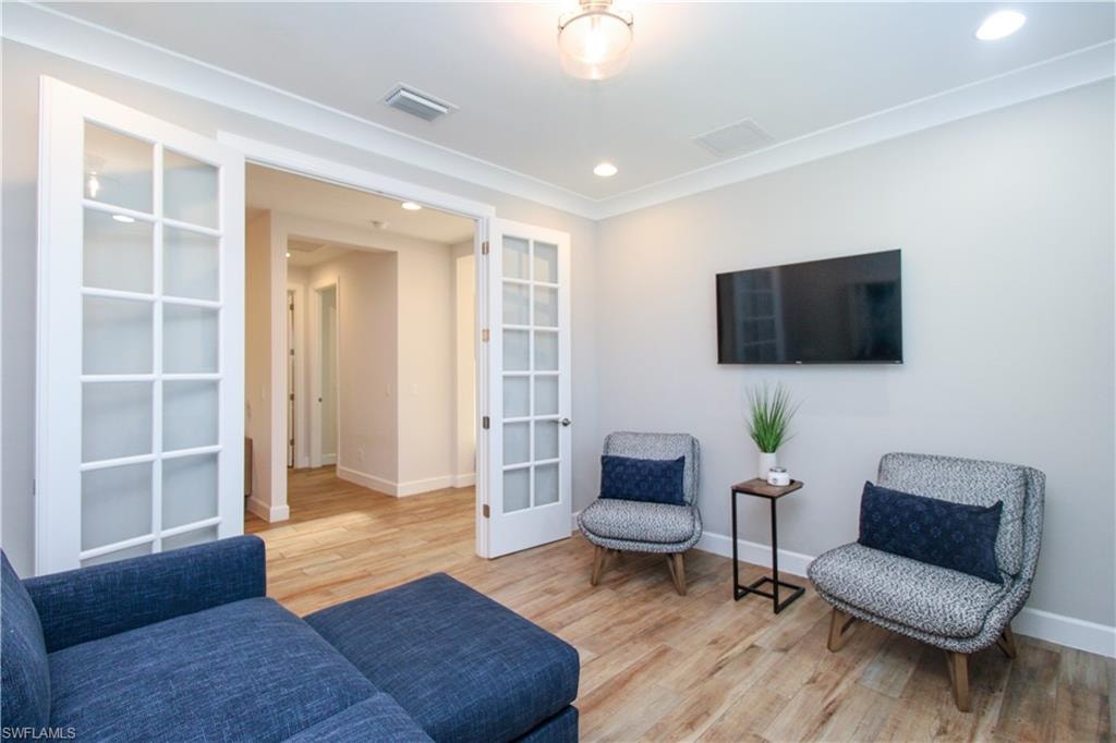 Sitting room featuring french doors and light wood-type flooring