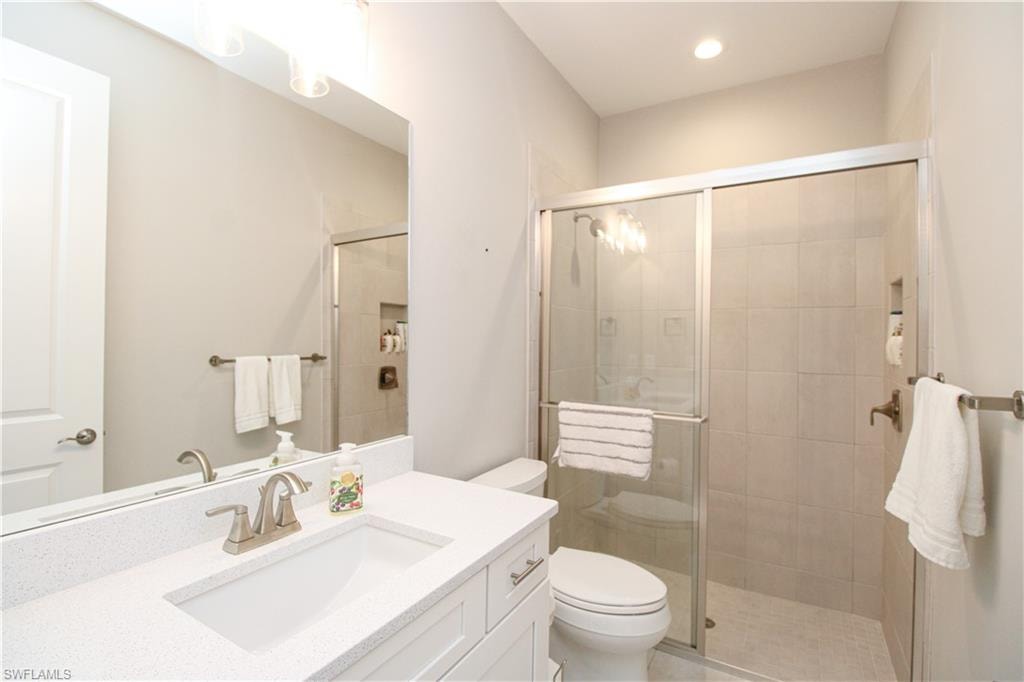 Bathroom with an enclosed shower, vanity, and toilet