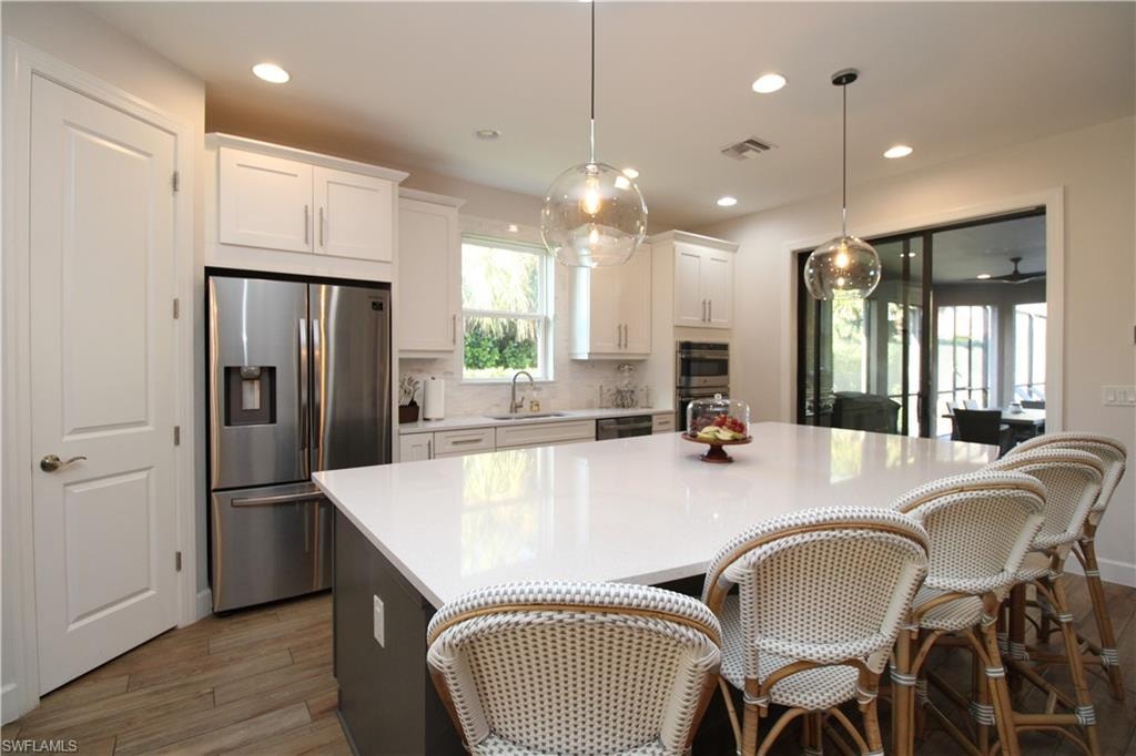 Kitchen featuring white cabinets, dark hardwood / wood-style flooring, stainless steel appliances, and sink