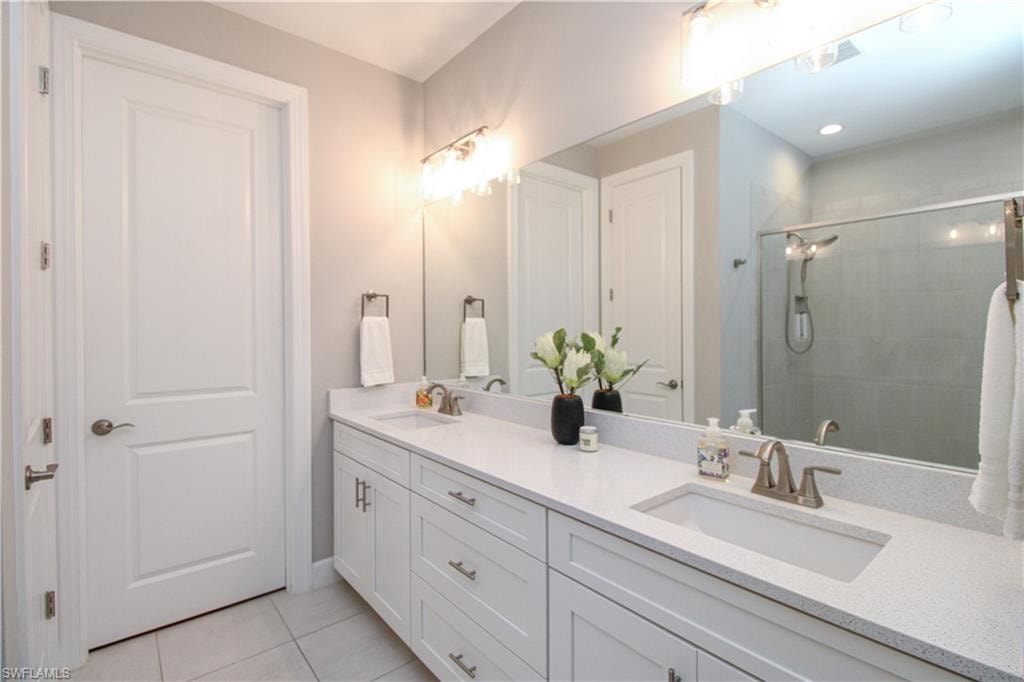 Bathroom with tile patterned flooring, vanity, and walk in shower