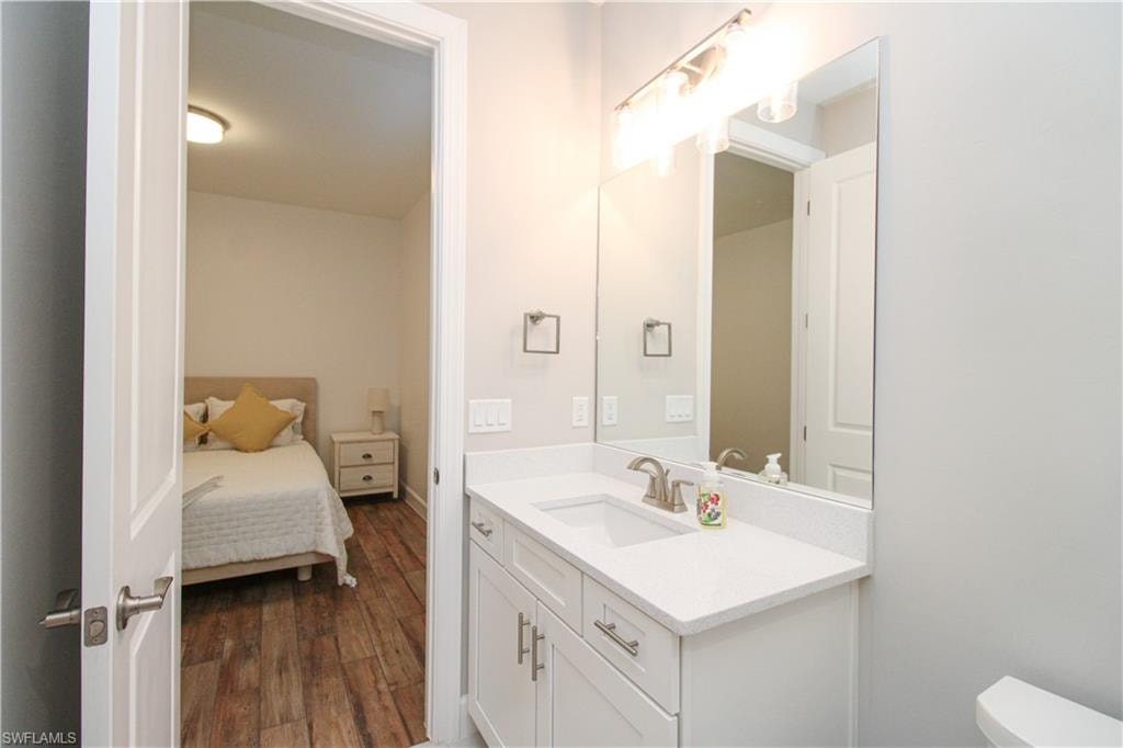 Bathroom featuring hardwood / wood-style floors, vanity, and toilet