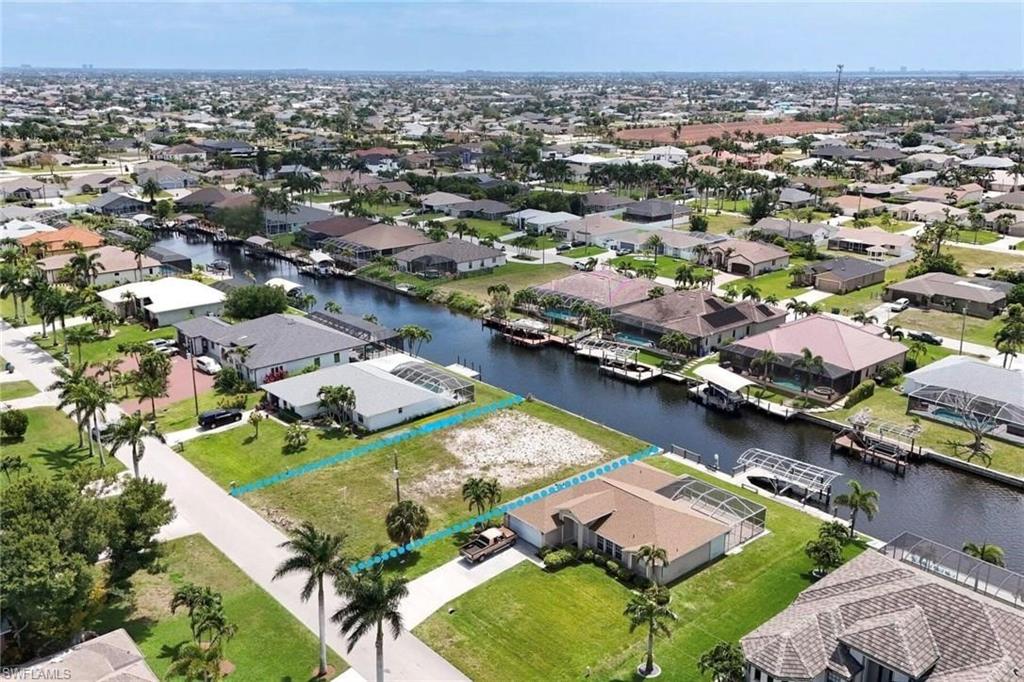 Aerial perspective of suburban area featuring a nearby body of water