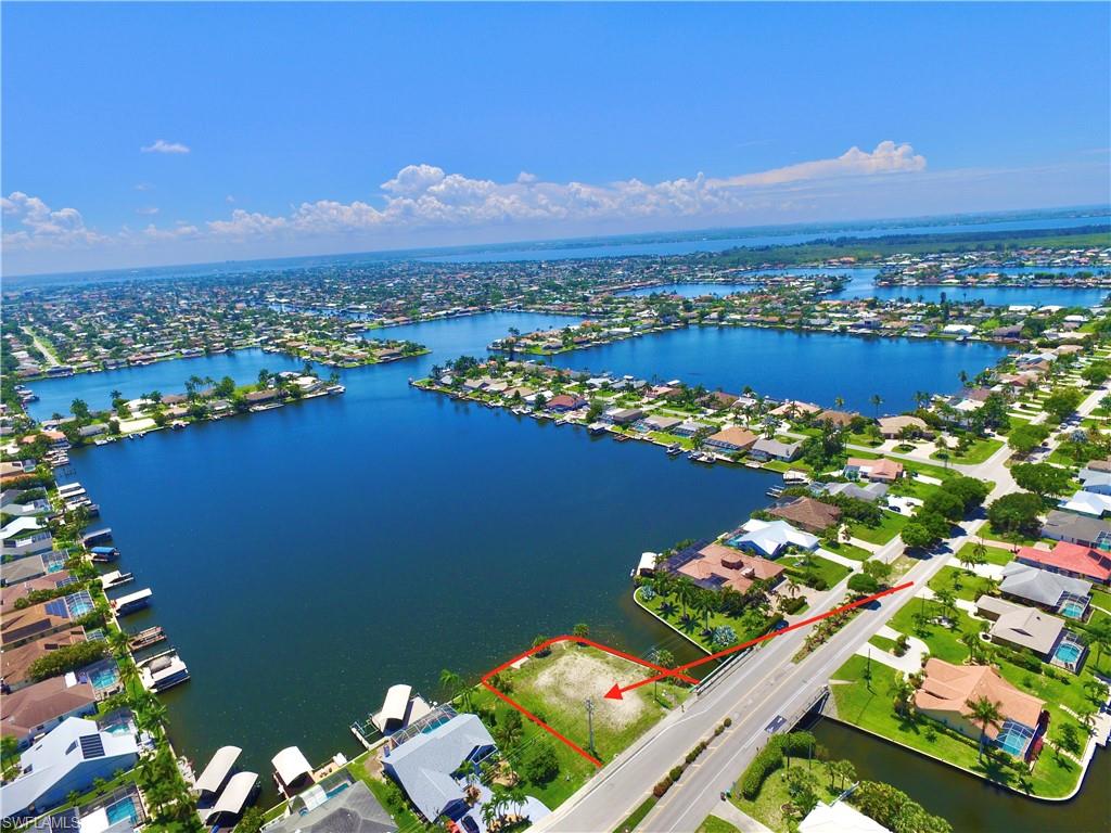 Aerial perspective of suburban area featuring property parcel outlined and a nearby body of water
