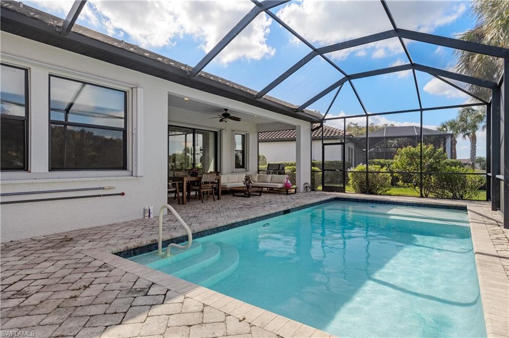 Swimming pool with a sunroom, a lanai, an outdoor hangout area, a patio area, and ceiling fan
