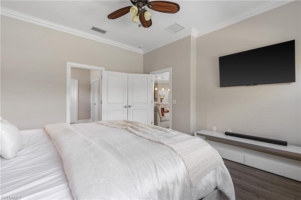 Bedroom featuring crown molding, wood finished floors, and ceiling fan