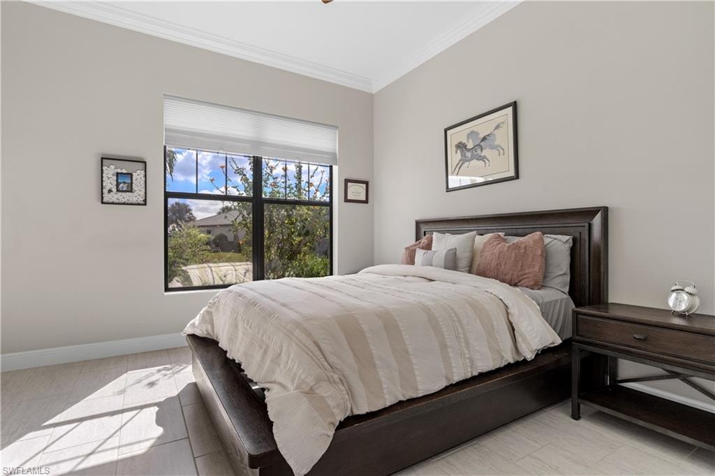 Bedroom with ornamental molding and baseboards