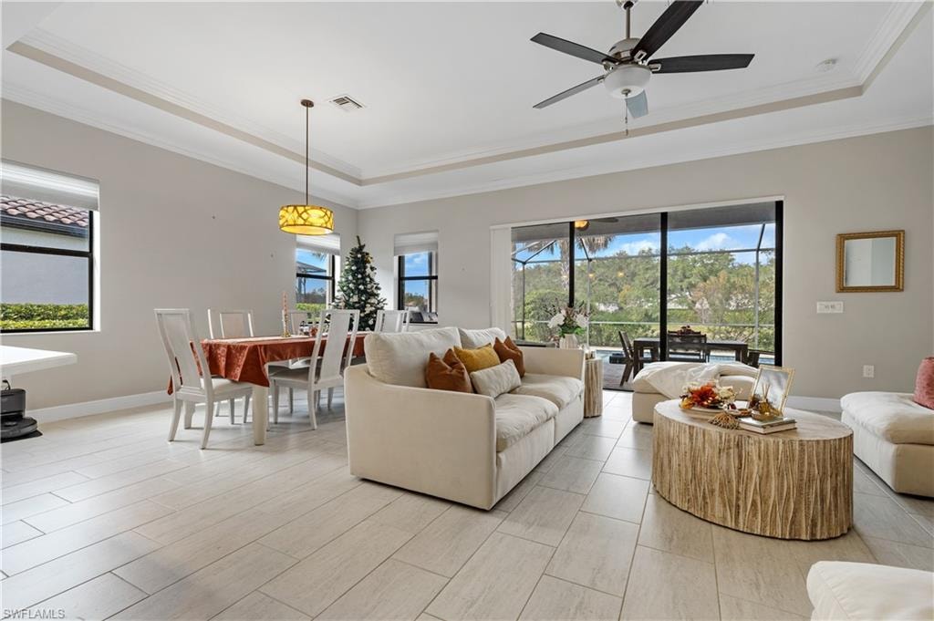 Living area featuring a raised ceiling and crown molding