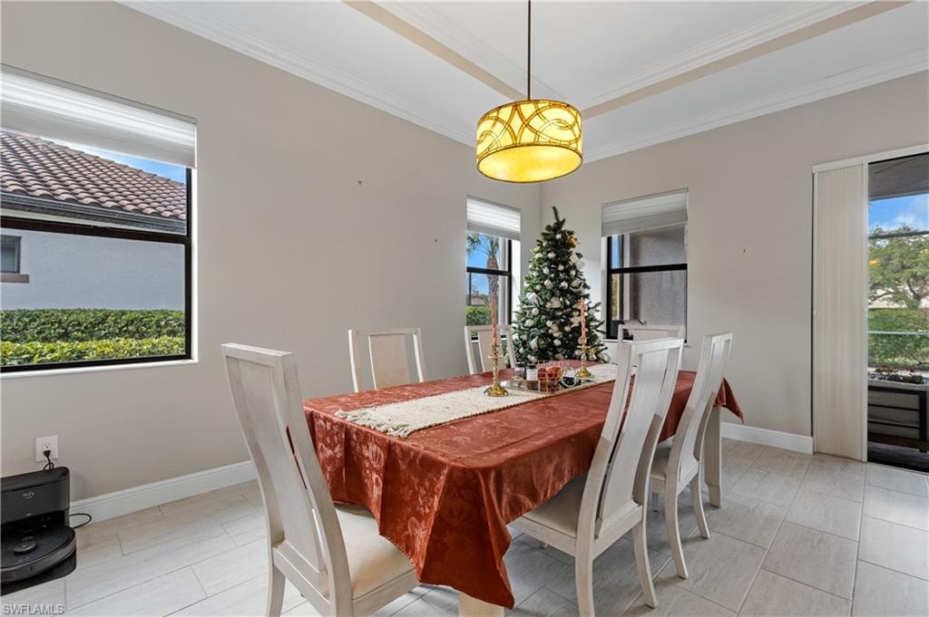 Dining space with ornamental molding and light tile patterned floors