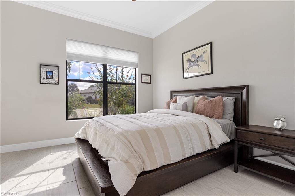 Bedroom with crown molding and baseboards