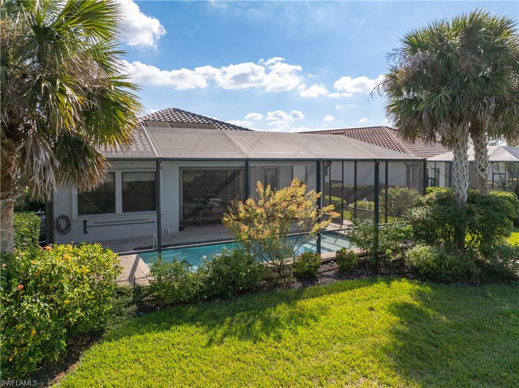Back of property featuring stucco siding, a sunroom, a tile roof, and an outdoor pool