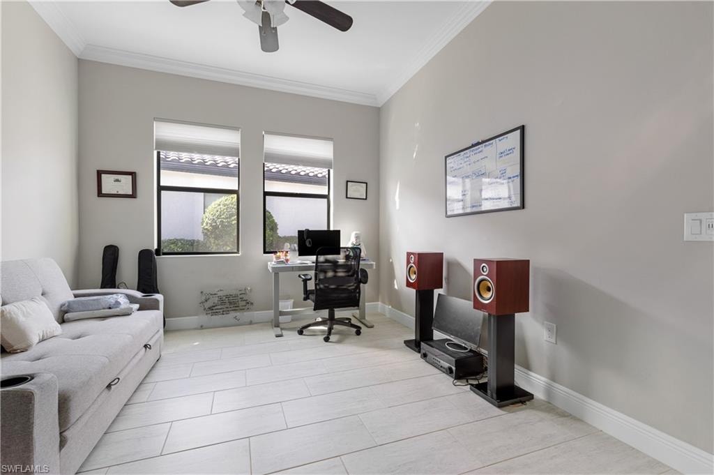 Office with ornamental molding, light tile patterned floors, and a ceiling fan