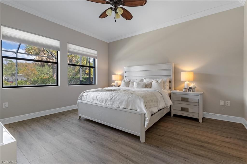 Bedroom with ornamental molding, wood finished floors, and a ceiling fan