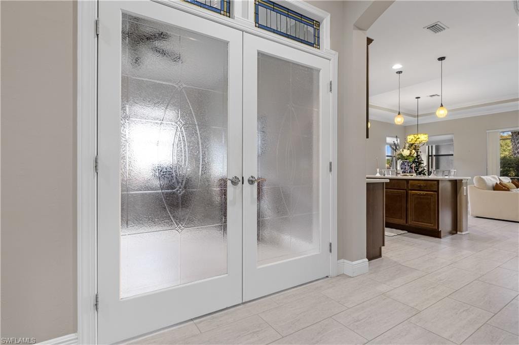 Full bath with french doors, vanity, and a raised ceiling