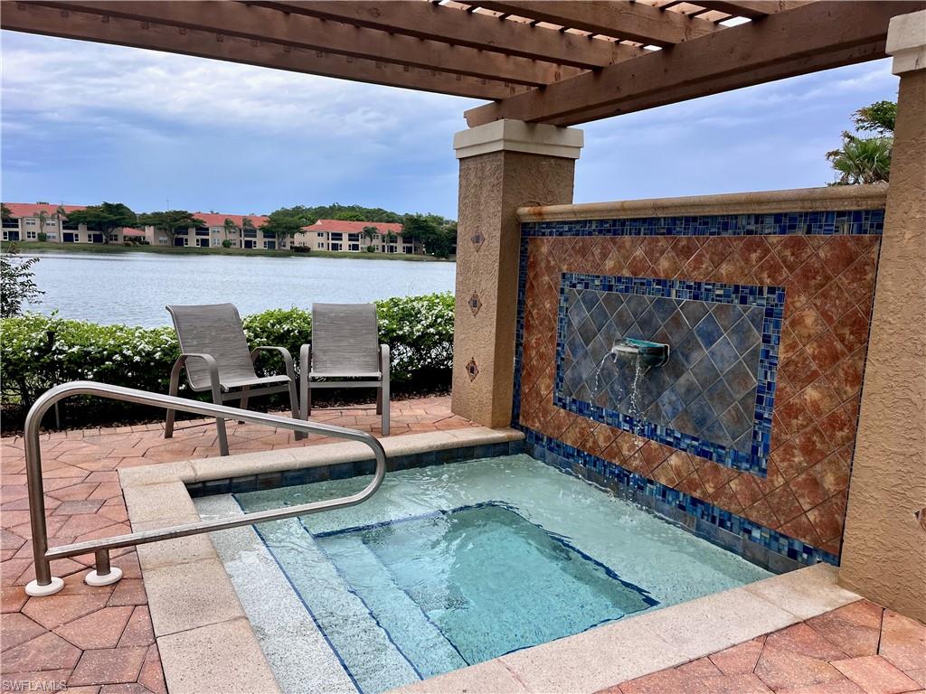 View of pool featuring a patio, a pergola, a water view, and a community hot tub