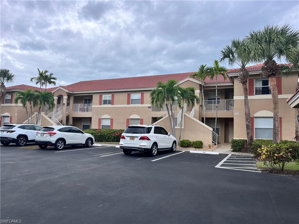 View of building exterior with one assigned parking spot located in front of the unit.