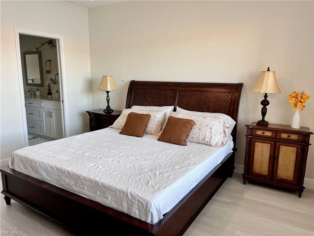 Bedroom featuring connected bathroom and light wood-style floors