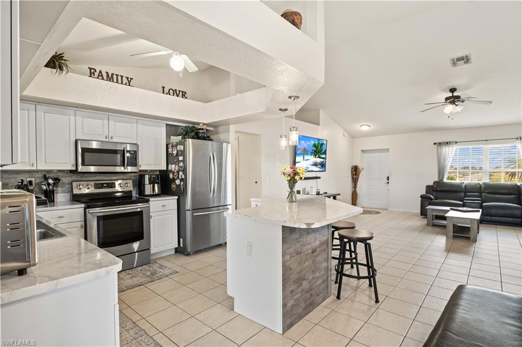 A large central island offers additional prep space and doubles as a casual dining area, perfect for gatherings.