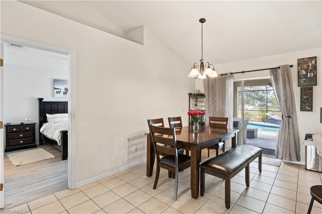 The dining area is bright and inviting, with large sliding glass doors that open directly to the pool area.