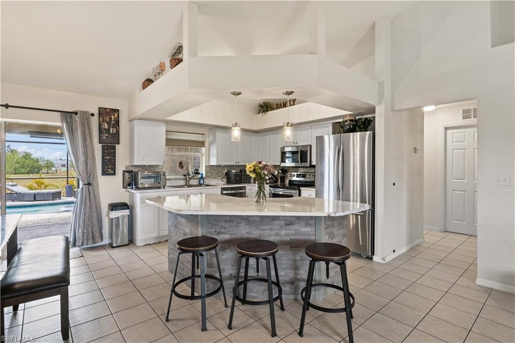 The kitchen is a chef’s dream, featuring sleek white cabinetry, high-end stainless-steel appliances, and expansive countertops that provide both functionality and style.