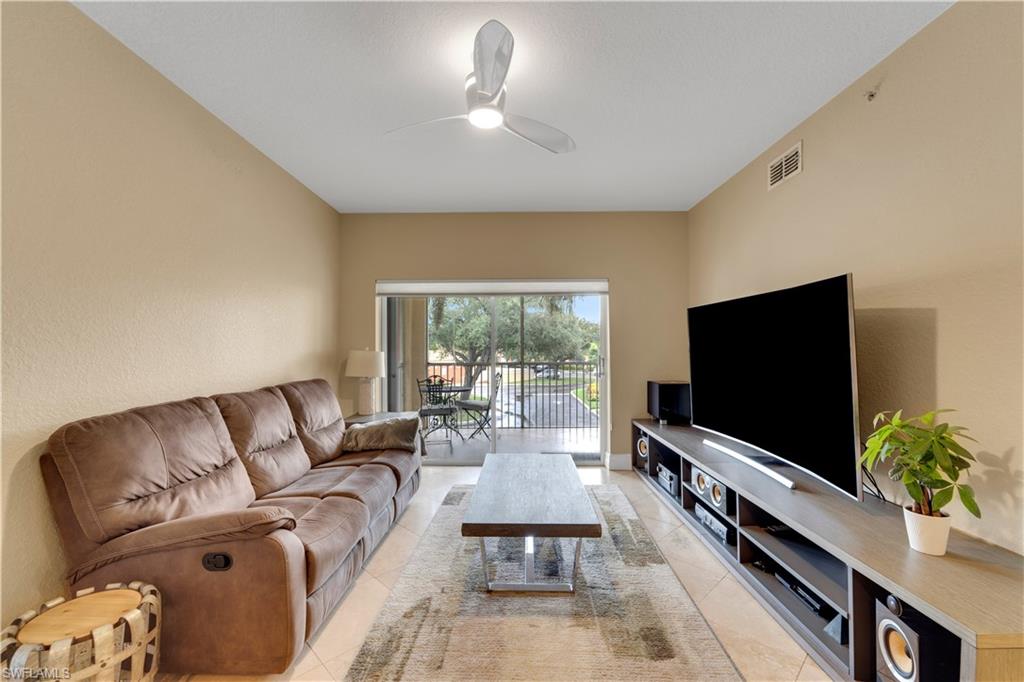 Living area with ceiling fan and light tile patterned floors