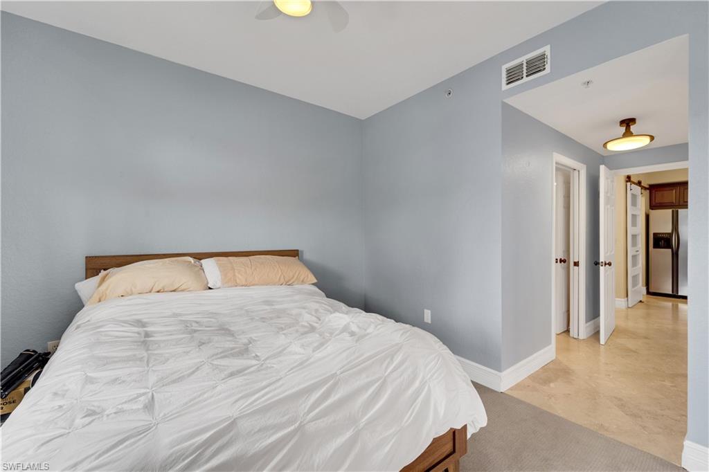 Bedroom featuring stainless steel fridge and a ceiling fan