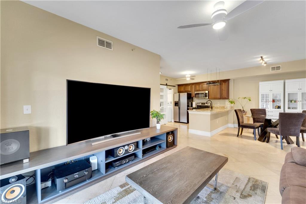 Living room featuring a ceiling fan and light tile patterned floors