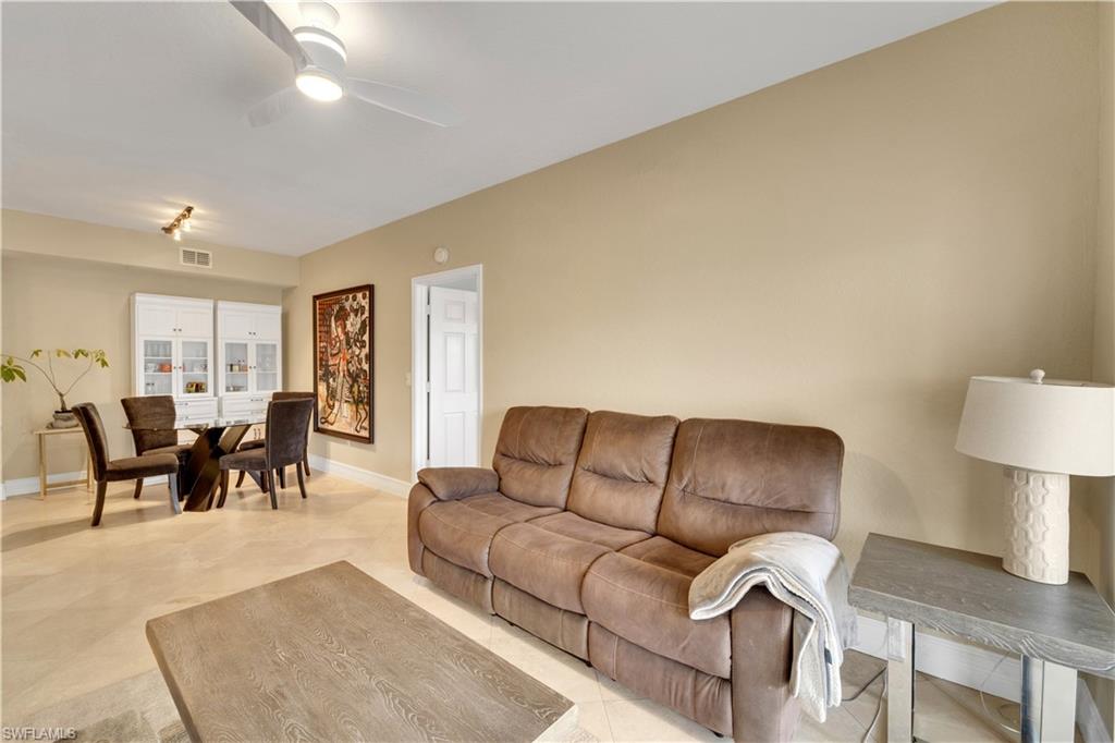 Living area with ceiling fan and light tile patterned floors
