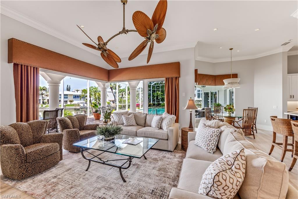 Living area with wood finished floors, ornamental molding, ceiling fan, and recessed lighting